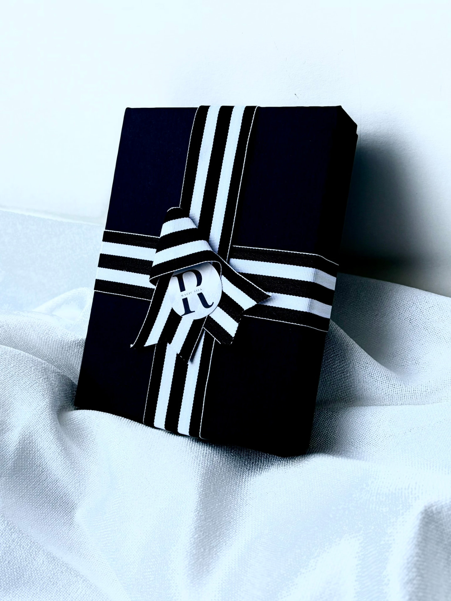 Detalle 1 de la caja signature RMAGIC SILK con cinta a rayas